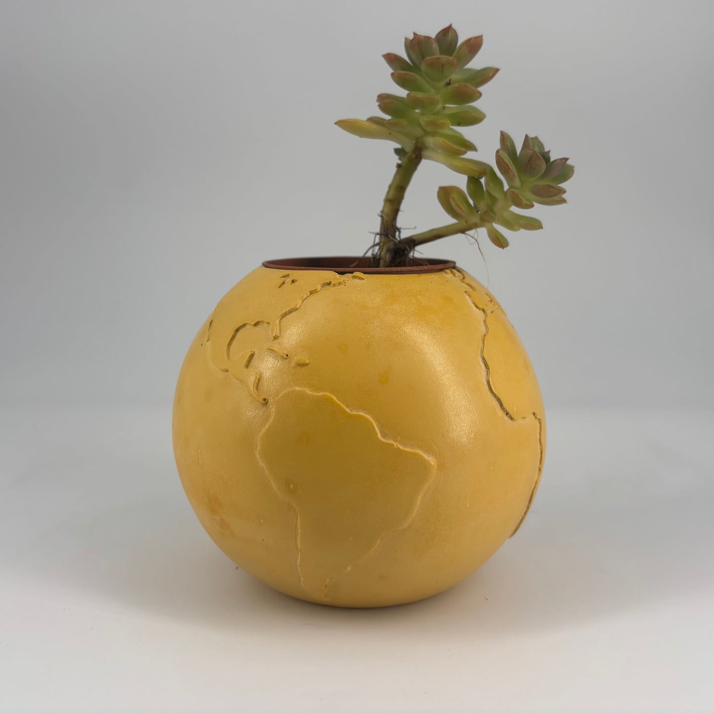 Coprivaso in ceramica artigianale Popikò giallo opaco, globo stilizzato fatto a mano, design contemporaneo Made in Italy.
